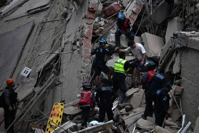Rescuers evacuate a person from a collapsed building following an earthquake in Caracas on June 24, 2026. Two earthquakes of magnitude 7.2 and 7.5 struck the same area of Venezuela on the evening of June 24, causing buildings to collapse, according to the United States Geological Survey (USGS) and AFP journalists. The quakes drove residents of the capital, Caracas, into the streets. (Photo by Juan BARRETO / AFP)