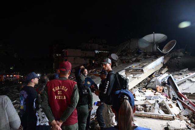 People and authorities stand next to a collapsed building in the San Bernardino neighbourhood following an earthquake in Caracas on June 24, 2026. Two earthquakes of magnitude 7.2 and 7.5 struck the same area of Venezuela on the evening of June 24, causing buildings to collapse, according to the United States Geological Survey (USGS) and AFP journalists. The quakes drove residents of the capital, Caracas, into the streets. (Photo by Juan BARRETO / AFP)