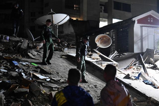 Members of the National Armed Forces examine a collapsed building in the San Bernardino neighbourhood following an earthquake in Caracas on June 24, 2026. Two earthquakes of magnitude 7.2 and 7.5 struck the same area of Venezuela on the evening of June 24, causing buildings to collapse, according to the United States Geological Survey (USGS) and AFP journalists. The quakes drove residents of the capital, Caracas, into the streets. (Photo by Juan BARRETO / AFP)