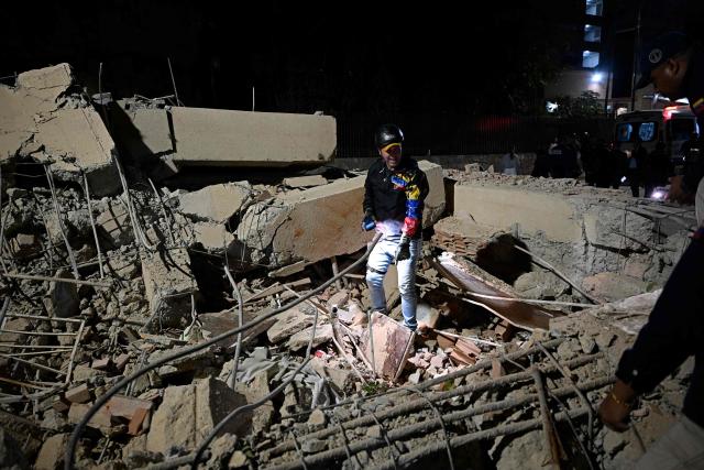 A rescuer searches through the rubble of a collapsed building following an earthquake in Caracas on June 24, 2026. Two earthquakes of magnitude 7.2 and 7.5 struck the same area of Venezuela on the evening of June 24, causing buildings to collapse, according to the United States Geological Survey (USGS) and AFP journalists. The quakes drove residents of the capital, Caracas, into the streets. (Photo by Federico PARRA / AFP)