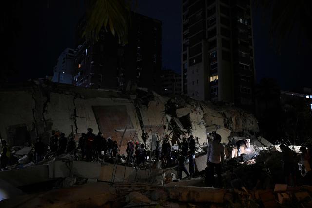 Rescuers search through the rubble of a collapsed building in the Altamira neighbourhood following an earthquake in Caracas on June 24, 2026. Two earthquakes of magnitude 7.2 and 7.5 struck the same area of Venezuela on the evening of June 24, causing buildings to collapse, according to the United States Geological Survey (USGS) and AFP journalists. The quakes drove residents of the capital, Caracas, into the streets. (Photo by Federico PARRA / AFP)
