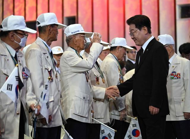 South Korean President Lee Jae Myung greets war veterans during a ceremony marking the 76th anniversary of the outbreak of the Korean War in Suwon on June 25, 2026. (Photo by Jung Yeon-je / AFP)