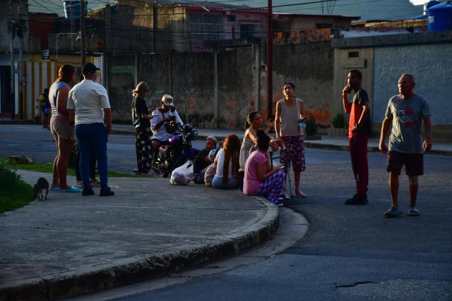 People gather on a street following an earthquake in Valencia, Venezuela on June 24, 2026. Two earthquakes of magnitude 7.2 and 7.5 struck the same area of Venezuela on the evening of June 24, causing buildings to collapse, according to the United States Geological Survey (USGS) and AFP journalists. The quakes drove residents of the capital, Caracas, into the streets. (Photo by Jacinto OLIVEROS / AFP)