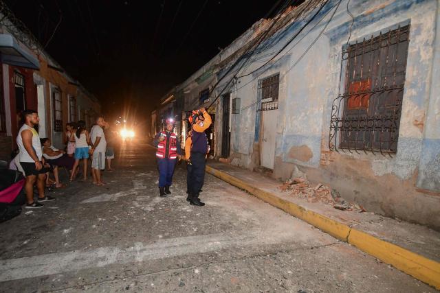 Carabobo Civil Protection workers inspect the site of a damaged building following an earthquake in Valencia, Venezuela on June 24, 2026. Two earthquakes of magnitude 7.2 and 7.5 struck the same area of Venezuela on the evening of June 24, causing buildings to collapse, according to the United States Geological Survey (USGS) and AFP journalists. The quakes drove residents of the capital, Caracas, into the streets. (Photo by Jacinto OLIVEROS / AFP)