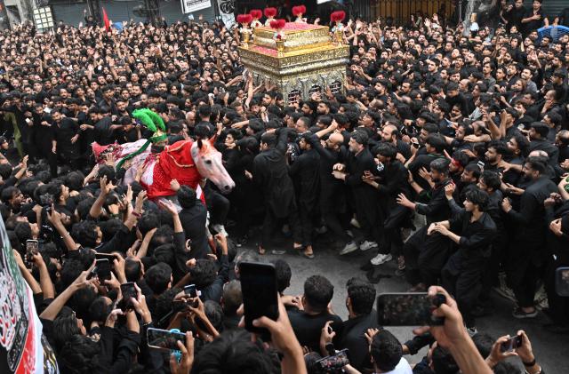 Shiite Muslims participate in a Muharram procession on the ninth day of Ashura in Lahore on June 25, 2026. (Photo by Arif ALI / AFP)