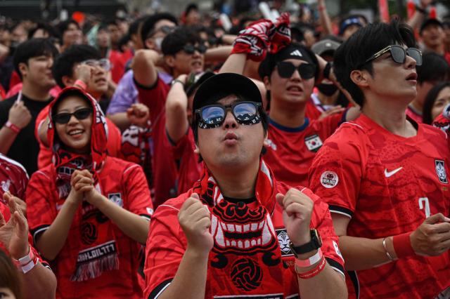 South Korean fans react as they watch the 2026 World Cup football match between South Korea and South Africa on big screens at Gwanghwamun Square in Seoul on June 25, 2026. (Photo by Jade GAO / AFP)