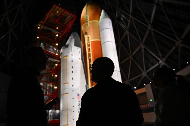 TOPSHOT - People view NASA’s Space Shuttle Endeavour as it stands stacked complete in a launch-ready vertical display with the ET-94 External Fuel Tank and a pair of Solid Rocket Boosters (SRBs) inside the Samuel Oschin Shuttle Gallery at the California Science Center in Los Angeles, on June 24, 2026. The Space Shuttle Endeavour exhibit will open on November 13, 2026 as part of a 200,000-square-foot expansion with the Samuel Oschin Air and Space Center. (Photo by Patrick T. Fallon / AFP)