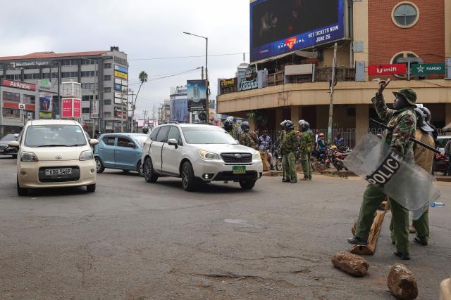 Kenyan police officers man a roadblock in the Central Business District (CBD) in the Kangemi neighbourhood ahead of the planned demonstrations to mark the second anniversary of the deadly June 2024 youth-led anti-Finance Bill protests, which saw demonstrators storm Parliament, in Nairobi on June 25, 2026. Thousands of Kenyans protested in June 2024 against economic hardship and corruption, eventually storming parliament to force the cancellation of new taxes. (Photo by Tony KARUMBA / AFP)