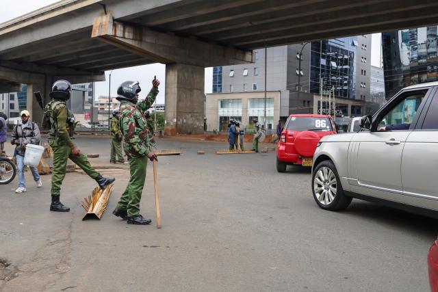 Kenyan police officers man a roadblock in the Central Business District (CBD) in the Kangemi neighbourhood ahead of the planned demonstrations to mark the second anniversary of the deadly June 2024 youth-led anti-Finance Bill protests, which saw demonstrators storm Parliament, in Nairobi on June 25, 2026. Thousands of Kenyans protested in June 2024 against economic hardship and corruption, eventually storming parliament to force the cancellation of new taxes. (Photo by Tony KARUMBA / AFP)