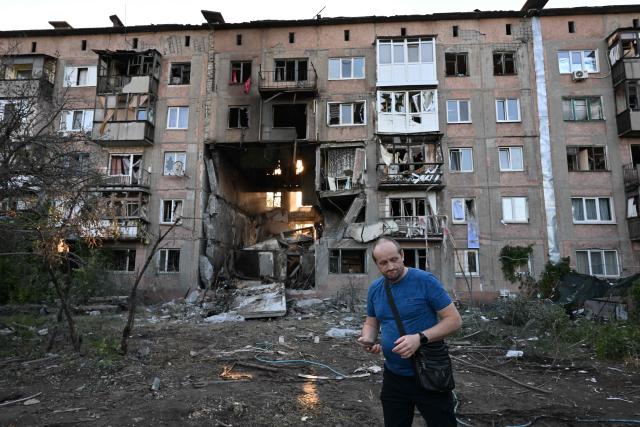 A man walks in front of a heavily damaged multi-storey apartment building following a recent attack, which local Russian-installed officials called a Ukrainian drone strike, in the town of Gorlivka in the Donetsk region, Russian-controlled Ukraine, on June 24, 2026, amid the ongoing Russian-Ukrainian conflict. (Photo by AFP)