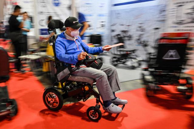 A man tests a wheelchair during the Shanghai International Medical Devices Exhibition in Shanghai on June 25, 2026. (Photo by HECTOR RETAMAL / AFP)