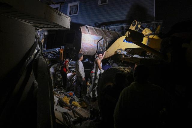 Volunteers search for people in a damaged building following an earthquake in Catia La Mar, La Guaira state, some 30km north-west of Caracas, early on June 25, 2026. Powerful twin earthquakes have killed 32 people and injured more than 700, the nation's interim president said on June 25, after the massive shocks collapsed entire buildings and sent people running in panic. (Photo by Federico PARRA / AFP)
