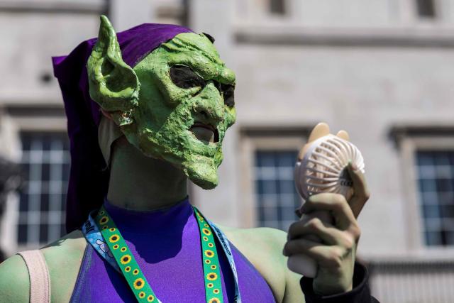 A Spider-man fan, in costume as the Green Goblin character, tries to cool off in the heat while waiting for a promotional event for the upcoming premiere of the film "Spider-Man: Brand New Day", in central London on June 25, 2026. (Photo by Brook Mitchell / AFP)
