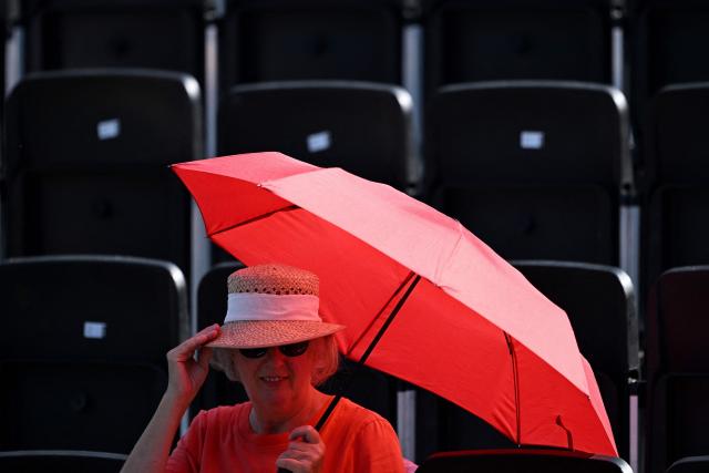 A woman shelters under an umbrella against the heat ahead of a women's doubles match of the WTA 500 Bad Homburg Open tennis tournament in Bad Homburg, western Germany on June 25, 2026. (Photo by Kirill KUDRYAVTSEV / AFP)
