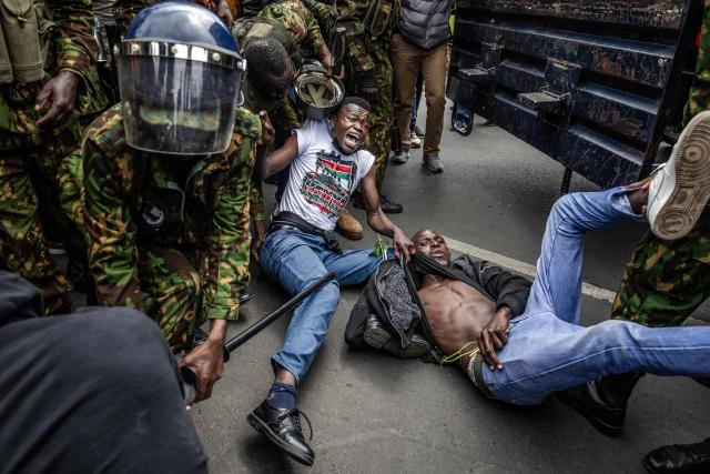 TOPSHOT - Protesters react while being arrested by Kenyan police officers outside Parliament buildings during demonstrations marking the second anniversary of the deadly June 2024 youth-led anti-Finance Bill protests, which saw demonstrators storm Parliament, in Nairobi on June 25, 2026. Kenyan police put on a massive show of force on June 26 in a bid to prevent protests marking two years since a landmark Gen Z uprising. Thousands of Kenyans took to the streets in June 2024 against economic hardship and corruption, eventually storming parliament to force the cancellation of new taxes. (Photo by Luis TATO / AFP)