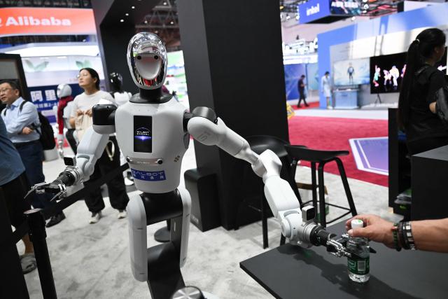 A Galbot humanoid robot serves a bottle of water at the NVIDIA booth during the China International Supply Chain Expo (CISCE) in Beijing on June 25, 2026. (Photo by Pedro PARDO / AFP)