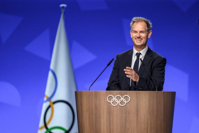 President of the Organizing Committee for the Alpes 2030 Winter Olympics Edgar Grospiron speaks during an extraordinary session of the International Olympic Committee (IOC) in Lausanne on June 25, 2026. The roughly 100 members of IOC approved on June 25, 2026 the re-inclusion of ski mountaineering in the program for the Alpes 2030 Olympic Winter Games, which will take place in the French Alps, after the "additional sport" made its Olympic debut at Milan-Cortina in 2026. (Photo by Fabrice COFFRINI / AFP)
