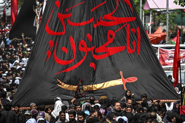 Shia Muslims hold a religous flag as they take part in a procession on the ninth-day of the Islamic holy month of Muharram in Islamabad on June 25, 2026. (Photo by Aamir QURESHI / AFP)