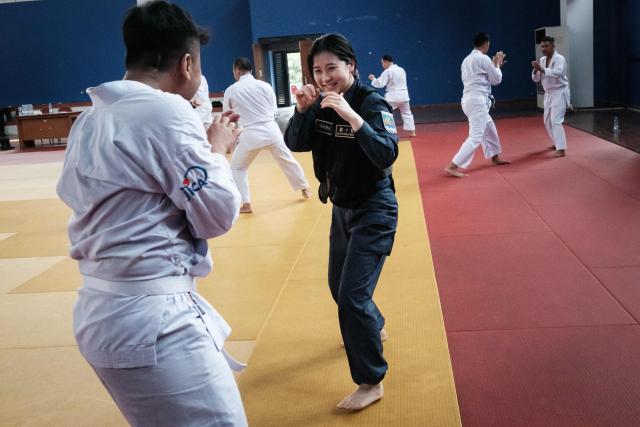A maritime law enforcement instructor from the Japan Coast Guard's Mobile Cooperation Team (MCT) teaches arrest and restraint techniques adapted from Japanese martial arts to officers of the Indonesian Maritime Security Agency (BAKAMLA) during a final training session ahead of their instructor certification examination at Gedung Judo in Jakarta on June 25, 2026. The Japan Coast Guard's Mobile Cooperation Team (MCT) provides capacity-building assistance to foreign coast guard agencies in 23 countries to help strengthen maritime security and ensure the safety of international sea lanes. (Photo by Yasuyoshi Chiba / AFP)