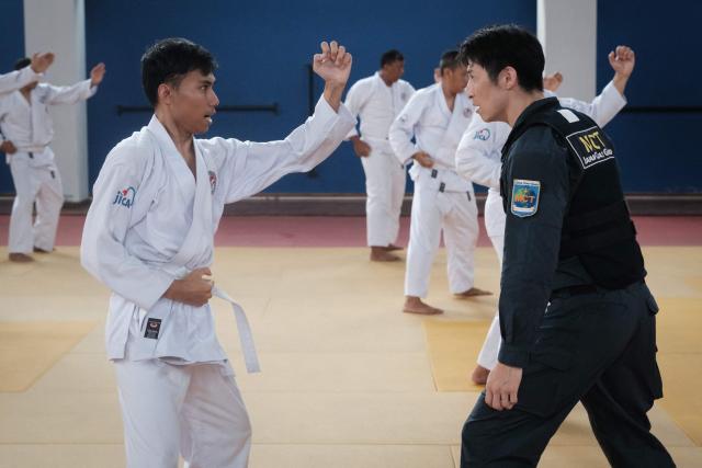 A maritime law enforcement instructor from the Japan Coast Guard's Mobile Cooperation Team (MCT) teaches arrest and restraint techniques adapted from Japanese martial arts to officers of the Indonesian Maritime Security Agency (BAKAMLA) during a final training session ahead of their instructor certification examination at Gedung Judo in Jakarta on June 25, 2026. The Japan Coast Guard's Mobile Cooperation Team (MCT) provides capacity-building assistance to foreign coast guard agencies in 23 countries to help strengthen maritime security and ensure the safety of international sea lanes. (Photo by Yasuyoshi Chiba / AFP)