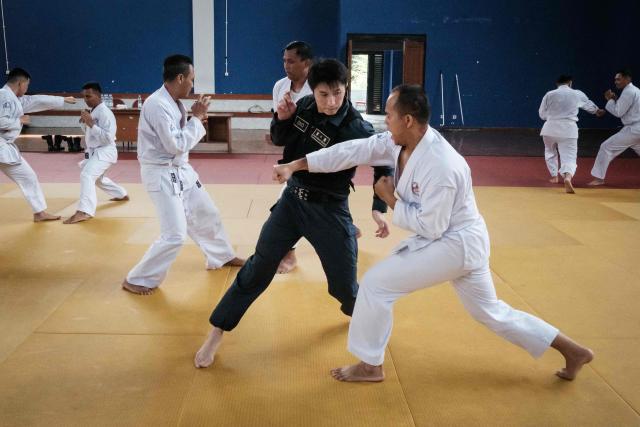 A maritime law enforcement instructor from the Japan Coast Guard's Mobile Cooperation Team (MCT) teaches arrest and restraint techniques adapted from Japanese martial arts to officers of the Indonesian Maritime Security Agency (BAKAMLA) during a final training session ahead of their instructor certification examination at Gedung Judo in Jakarta on June 25, 2026. The Japan Coast Guard's Mobile Cooperation Team (MCT) provides capacity-building assistance to foreign coast guard agencies in 23 countries to help strengthen maritime security and ensure the safety of international sea lanes. (Photo by Yasuyoshi Chiba / AFP)