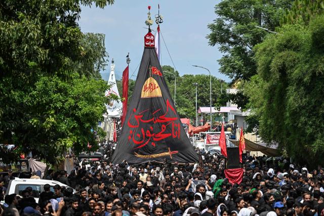 Shia Muslims hold a religous flag as they take part in a procession on the ninth-day of the Islamic holy month of Muharram in Islamabad on June 25, 2026. (Photo by Aamir QURESHI / AFP)