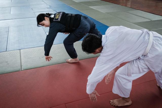 A maritime law enforcement instructor from the Japan Coast Guard's Mobile Cooperation Team (MCT) teaches arrest and restraint techniques adapted from Japanese martial arts to officers of the Indonesian Maritime Security Agency (BAKAMLA) during a final training session ahead of their instructor certification examination at Gedung Judo in Jakarta on June 25, 2026. The Japan Coast Guard's Mobile Cooperation Team (MCT) provides capacity-building assistance to foreign coast guard agencies in 23 countries to help strengthen maritime security and ensure the safety of international sea lanes. (Photo by Yasuyoshi Chiba / AFP)
