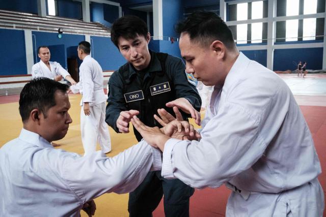 A maritime law enforcement instructor from the Japan Coast Guard's Mobile Cooperation Team (MCT) teaches arrest and restraint techniques adapted from Japanese martial arts to officers of the Indonesian Maritime Security Agency (BAKAMLA) during a final training session ahead of their instructor certification examination at Gedung Judo in Jakarta on June 25, 2026. The Japan Coast Guard's Mobile Cooperation Team (MCT) provides capacity-building assistance to foreign coast guard agencies in 23 countries to help strengthen maritime security and ensure the safety of international sea lanes. (Photo by Yasuyoshi Chiba / AFP)