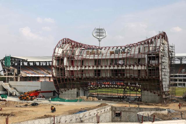 Workers are seen at the construction site of an international cricket stadium with Hindu god Shiva-themed architecture, including a pellet drum-inspired media centre, on the outskirts of Varanasi on June 25, 2026. (Photo by Niharika KULKARNI / AFP)