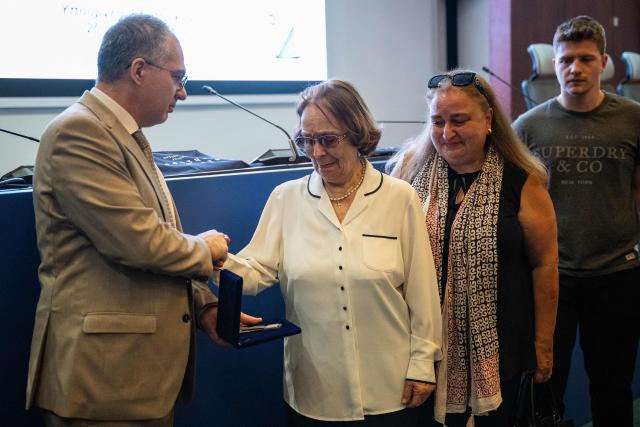 Relatives of Evangelos Kerasiotis react as they receive his personal belongings during a ceremony for the return of personal belongings of Greek prisoners from Nazi forced labor camps to their families, held as part of the international StolenMemory campaign, at the Ministry of Foreign Affairs in Athens on June 25, 2026. (Photo by Angelos TZORTZINIS / AFP)