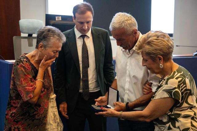 Relatives of Dimitris Vafeiadis react as they receive his personal belongings during a ceremony for the return of personal belongings of Greek prisoners from Nazi forced labor camps to their families, held as part of the international StolenMemory campaign, at the Ministry of Foreign Affairs in Athens on June 25, 2026. (Photo by Angelos TZORTZINIS / AFP)