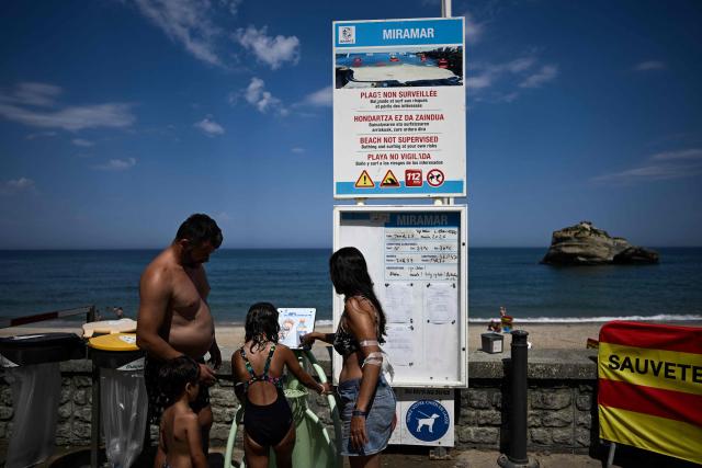 A family stops at a drinking water dispenser on Miramar beach as France faces a severe early-summer heatwave affecting much of western Europe, in Biarritz, French Basque Country, on June 25, 2026. At least 101 million Europeans were expected to experience temperatures of over 35C today, in a punishing and increasingly deadly heatwave hotter than weather in parts of Africa. (Photo by Philippe LOPEZ / AFP)