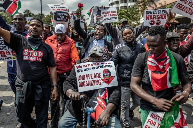 Protesters hold placards and chant anti-government slogans as they march during demonstrations marking the second anniversary of the deadly June 2024 youth-led anti-Finance Bill protests, which saw demonstrators storm Parliament, in Nairobi on June 25, 2026. Kenyan police put on a massive show of force on June 25 in a bid to prevent protests marking two years since a landmark Gen Z uprising. Thousands of Kenyans took to the streets in June 2024 against economic hardship and corruption, eventually storming parliament to force the cancellation of new taxes. (Photo by Luis TATO / AFP)