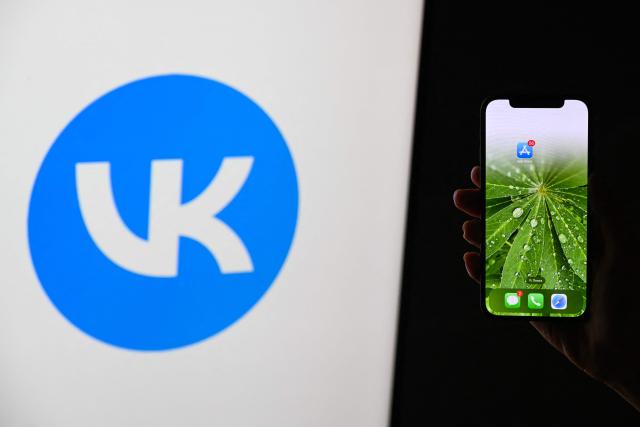This illustration photograph shows the logo of Russian social media platform VK displayed on a TV screen and AppStore logo displayed on a smartphone in Moscow on June 25, 2026. Apple has removed VKontakte, one of Russia's largest social networks, from its App Store, the Russian company said on June 25, 2026, with the Kremlin calling for an explanation from the California-based tech giant. VKontakte (VK) was launched in 2006 as Russia's answer to Facebook and has since grown to become one of the most popular websites and social media platforms in the country. (Photo by Igor IVANKO / AFP)