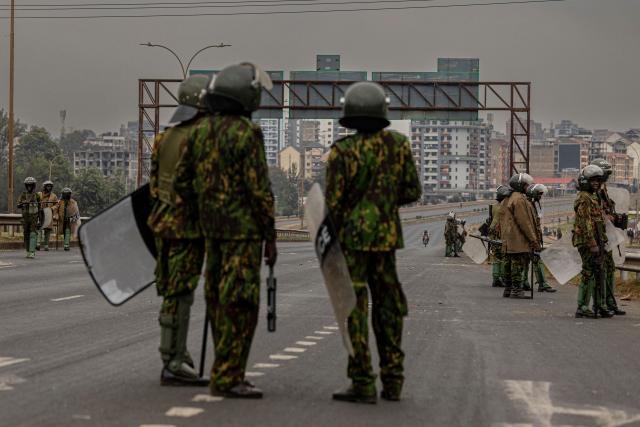 Kenyan police officers guard a roadblock ahead of demonstrations planned to mark the second anniversary of the deadly June 2024 youth-led anti-Finance Bill protests, which saw demonstrators storm Parliament, in Nairobi on June 25, 2026. Kenyan police put on a massive show of force on June 25 in a bid to prevent protests marking two years since a landmark Gen Z uprising. Thousands of Kenyans took to the streets in June 2024 against economic hardship and corruption, eventually storming parliament to force the cancellation of new taxes. (Photo by SIMON MAINA / AFP)