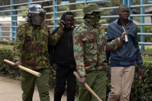 Kenyan police officers arrest protesters during demonstrations marking the second anniversary of the deadly June 2024 youth-led anti-Finance Bill protests, which saw demonstrators storm Parliament, in Nairobi on June 25, 2026. Kenyan police put on a massive show of force on June 25 in a bid to prevent protests marking two years since a landmark Gen Z uprising. Thousands of Kenyans took to the streets in June 2024 against economic hardship and corruption, eventually storming parliament to force the cancellation of new taxes. (Photo by SIMON MAINA / AFP)