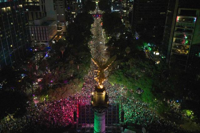 In this aerial view Mexican football fans celebrate their victory at the Angel de la Independencia in Mexico City on June 24, 2026, after the 2026 FIFA World Cup football match between Mexico and Czechia. (Photo by Claudia Rosel / AFP)