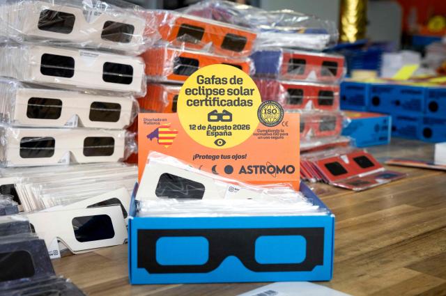 Eclipse viewing glasses certified with the  ISO 12312-2:2015 international safety standard which specifies requirements for direct observation of the sun, are displayed at Astromo, a space enthusiasts online store,  in Palma de Mallorca on June 25, 2026. According to Spain's National Astronomical Observatory, during the evening of Wednesday, August 12, 2026, a total solar eclipse will be visible from the Iberian Peninsula, marking the first such event in over a century. The path of totality of this eclipse will cross Spain from west to east and will pass throught numerous provincial capitals from La Coruna to Palma including Oviedo, Leon, Bilbao, Zaragoza, and Valencia. (Photo by Jaime REINA / AFP)