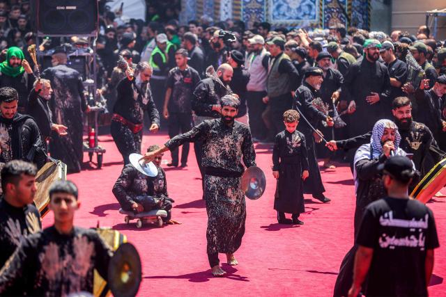 Shia Muslim devotees march in a mourning procession near the Shrine of Imam Abbas in Iraq's holy city of Karbala on June 25, 2026 at the peak of Ashura, a 10-day period commemorating the seventh century killing of Prophet Mohammed's grandson Imam Hussein. (Photo by AHMAD AL-RUBAYE / AFP)