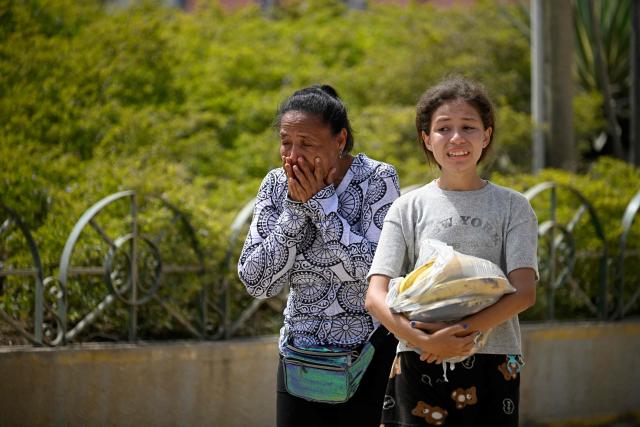 Women react in the street following an earthquake in Catia La Mar, La Guaira state, about 30 km northwest of Caracas, on June 25, 2026. A twin earthquake that was Venezuela's largest in over a century has killed at least 164 people and destroyed multiple buildings near the capital, where residents searched on June 25 for missing relatives. (Photo by Federico PARRA / AFP)