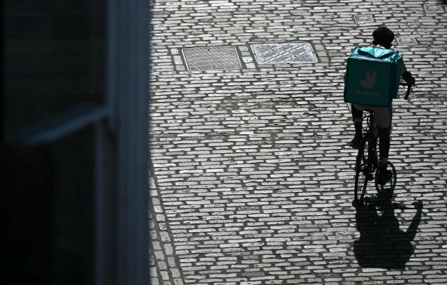 A Deliveroo delivery cyclist rides in the sun, in Guildford, on June 25, 2026, during a heatwave. The UK recorded its hottest ever June temperature on June 24 with the mercury rising to 36.1C in southern England, breaking the previous record of 35.6C set in 1976. (Photo by JUSTIN TALLIS / AFP)