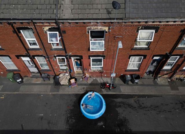 A family take advantage of the hot and sunny weather to wash rugs in the street by their home, in an eastern area of Leeds, northern England on June 25, 2026. The UK recorded its hottest ever June temperature on June 24 with the mercury rising to 36.1C in southern England, breaking the previous record of 35.6C set in 1976. (Photo by Oli SCARFF / AFP)