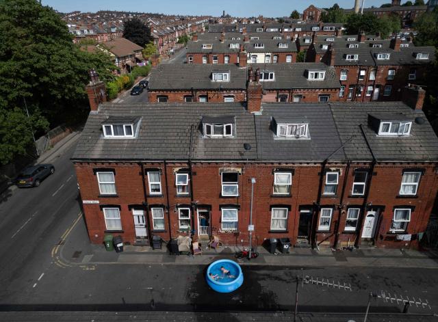 A family take advantage of the hot and sunny weather to wash rugs in the street by their home, in an eastern area of Leeds, northern England on June 25, 2026. The UK recorded its hottest ever June temperature on June 24 with the mercury rising to 36.1C in southern England, breaking the previous record of 35.6C set in 1976. (Photo by Oli SCARFF / AFP)