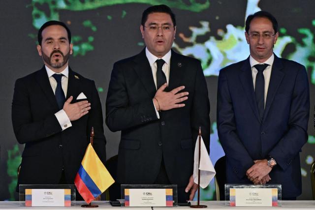 (L-R) Colombia's President-elect Abelardo de la Espriella, National Electoral Council (CNE) President Cristian Quiroz and Vice-President-elect Jose Manuel Restrepo, sing the national anthem before the presentation of the official credentials at the National Registry of Civil Status headquarters in Bogota on June 25, 2026.  (Photo by Luis ACOSTA / AFP)