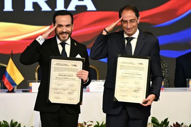 Colombia’s President-elect Abelardo de la Espriella (L) and Vice President-elect Jose Manuel Restrepo salute while posing with their official credentials at the National Registry of Civil Status headquarters in Bogota on June 25, 2026.  (Photo by Luis ACOSTA / AFP)
