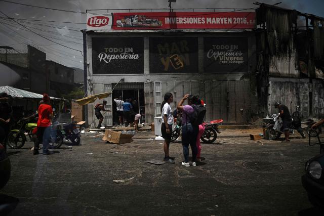 Picture taken through the window of a vehicle as looting erupted in Catia La Mar, La Guaira State, about 30 km northwest of Caracas, on June 25, 2026, following an earthquake. A twin earthquake that was Venezuela's largest in over a century has killed at least 164 people and destroyed multiple buildings near the capital, where residents searched on June 25 for missing relatives. (Photo by Federico PARRA / AFP)