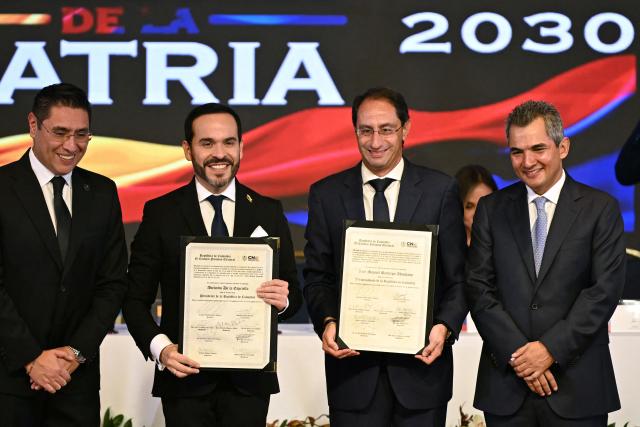 Colombia's President-elect Abelardo de la Espriella (2-L) and Vice President-elect Jose Manuel Restrepo (3-L), accompanied by National Electoral Council magistrate Alfonso Campo (R) and CNE president Cristian Quiroz (L), pose after receiving their official credentials at the National Registry of Civil Status headquarters in Bogota on June 25, 2026.  (Photo by Luis ACOSTA / AFP)