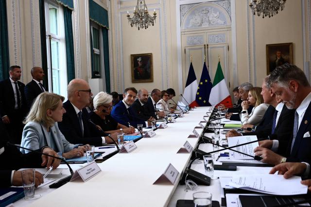 Italy's Prime Minister Giorgia Meloni (C-R) and France's President Emmanuel Macron (C-L) and members of their respective delegations attend a meeting as part of a Franco-Italian summit in Antibes, French Riviera, southern France on June 25, 2026. The talks mark the first Franco-Italian summit since a treaty on a strategic alliance came into force in 2021, elevating relations to a level comparable to that between France and Germany. (Photo by Manon Cruz / POOL / AFP)