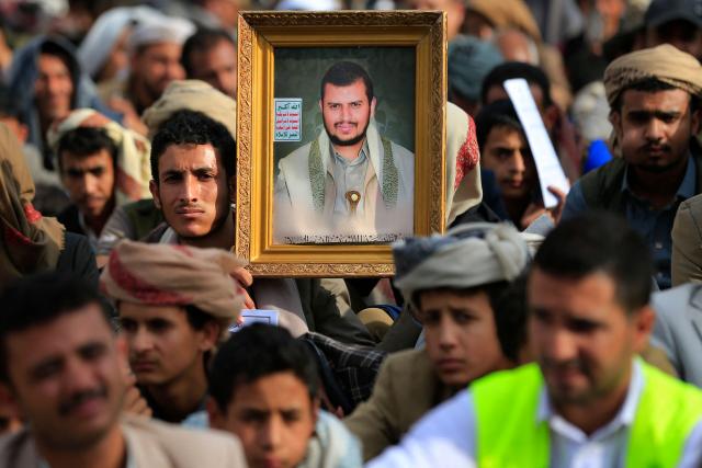 A Shiite Muslim Yemeni holds a portrait of Huthi leader Abdul-Malik al-Huthi, while listening to a speech being addressed by him during a ceremony commemorating Ashura, in Sanaa on June 25, 2026. The commemoration of Ashura consists of a ten-day mourning period starting on the first day of Muharram according to the Islamic calendar, marking the seventh-century slaying of Prophet Mohammed's grandson Imam Hussein. (Photo by Mohammed HUWAIS / AFP)