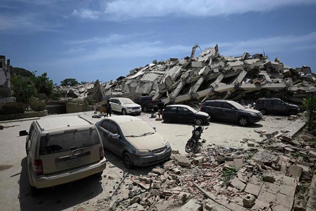 A view shows a large pile of rubble from a collapsed building with several dust-covered parked cars nearby following an earthquake in Los Corales, La Guaira state, about 38 km northwest of Caracas, on June 25, 2026. A twin earthquake that was Venezuela's largest in over a century has killed at least 188 people and destroyed multiple buildings near the capital, where residents searched on June 25 for missing relatives. (Photo by Federico PARRA / AFP)